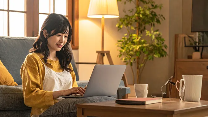 綺麗なリビングでノートパソコンを使っている女性